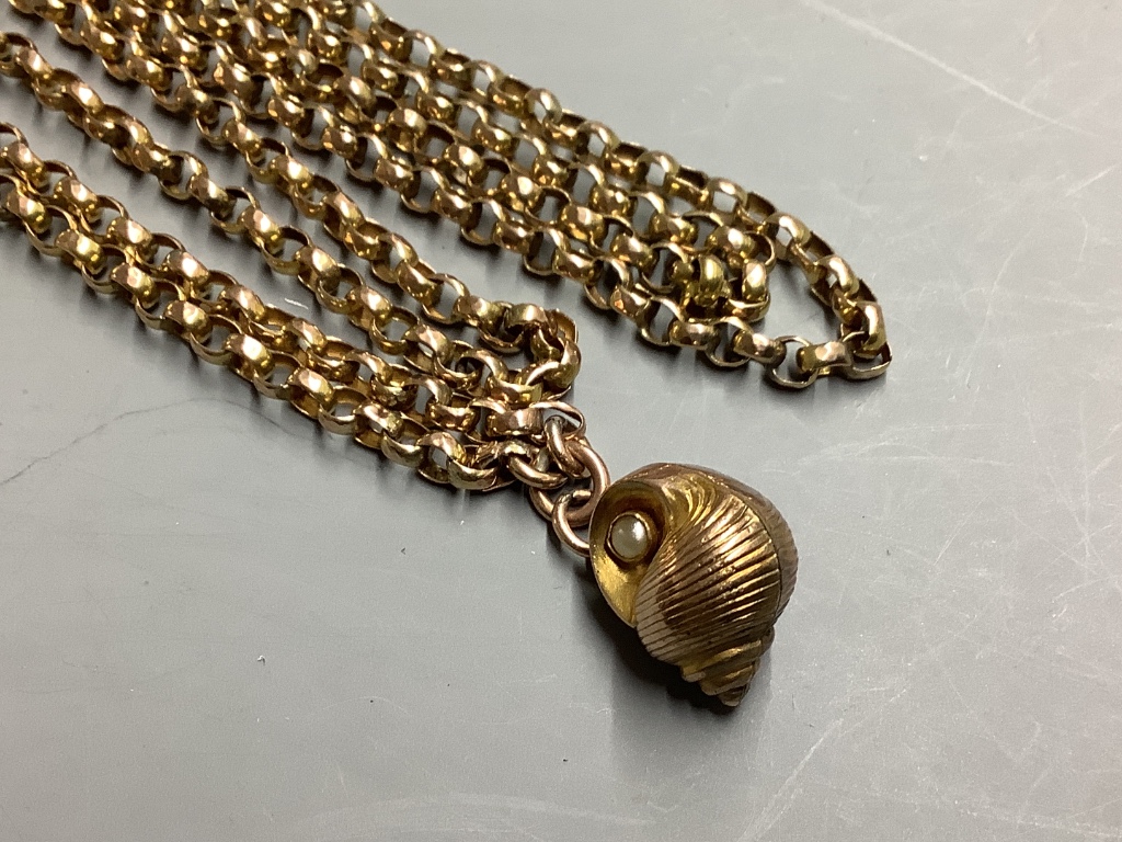 An early 20th century yellow metal (stamped 9c) guard chain, hung with a yellow metal and seed pearl set shell charm